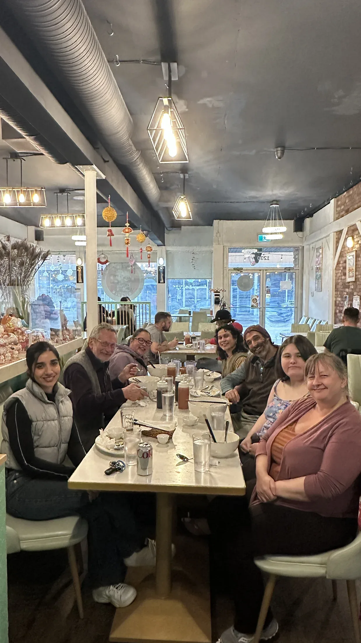 People gathered around a long table in a bright restaurant.